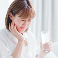 woman drinking chilled water experiencing sensitive teeth